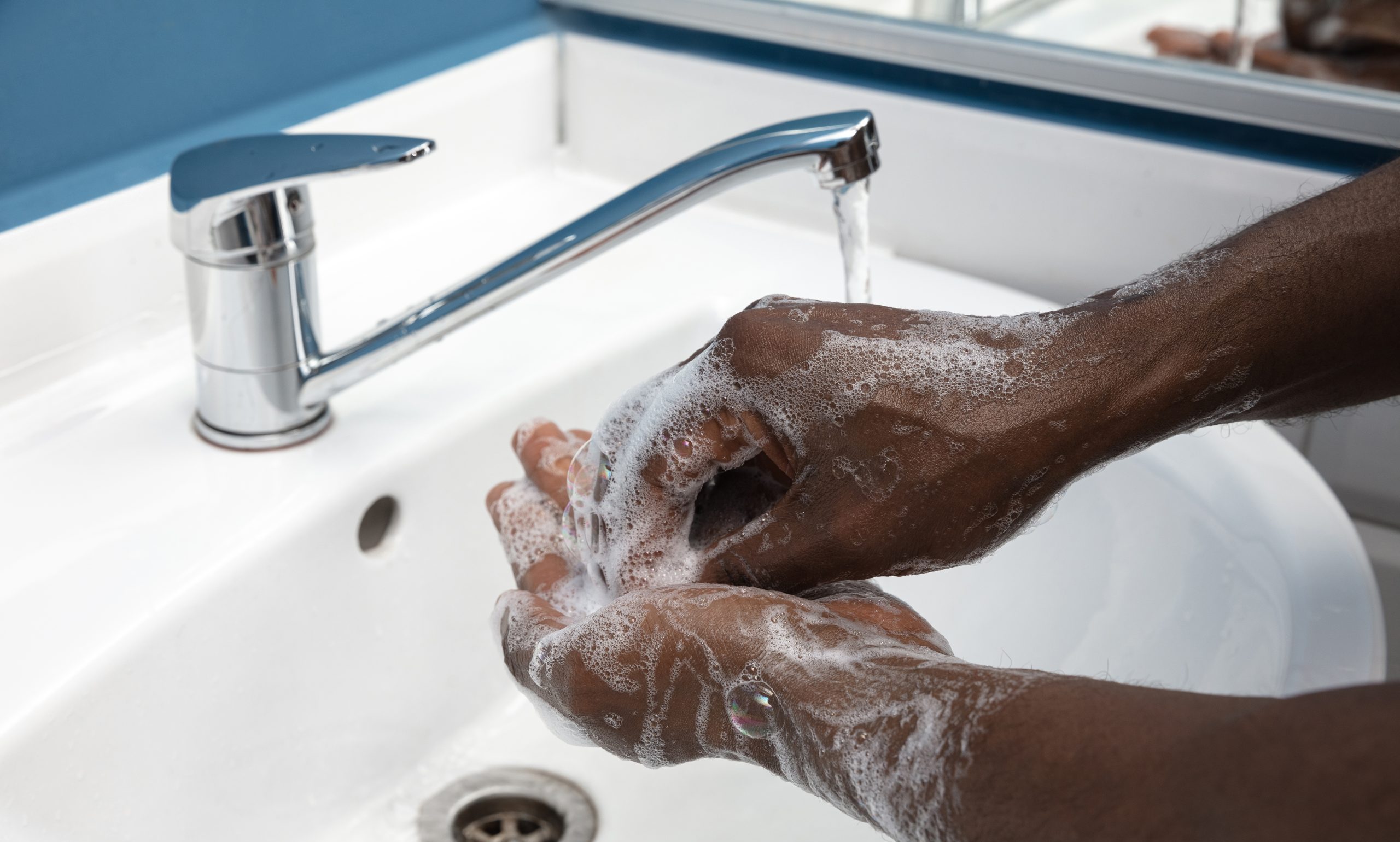Man washing hands carefully with soap and sanitizer, close up. Prevention of pneumonia virus spreading, protection against coronavirus pandemia. Hygiene, sanitary, cleanliness, disinfection. Safety.